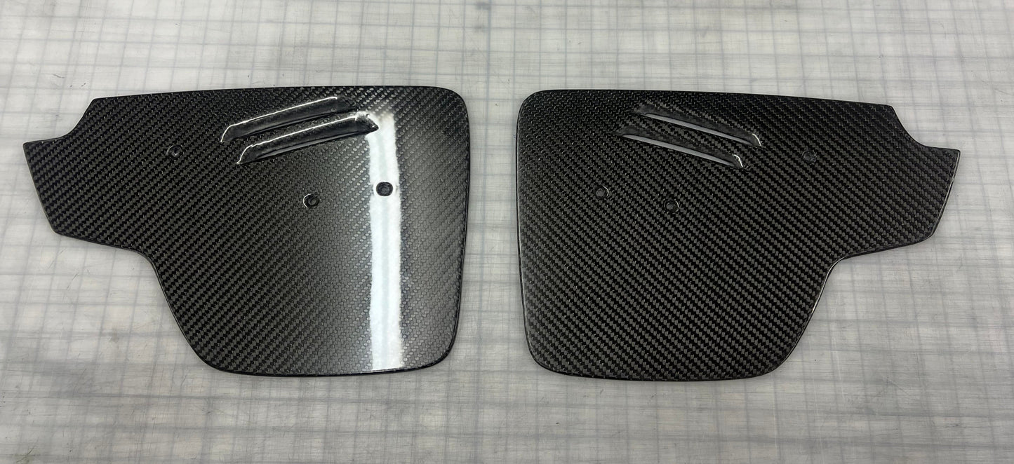 A pair of carbon fiber Dodge Viper wing endplates laid on a flat surface.