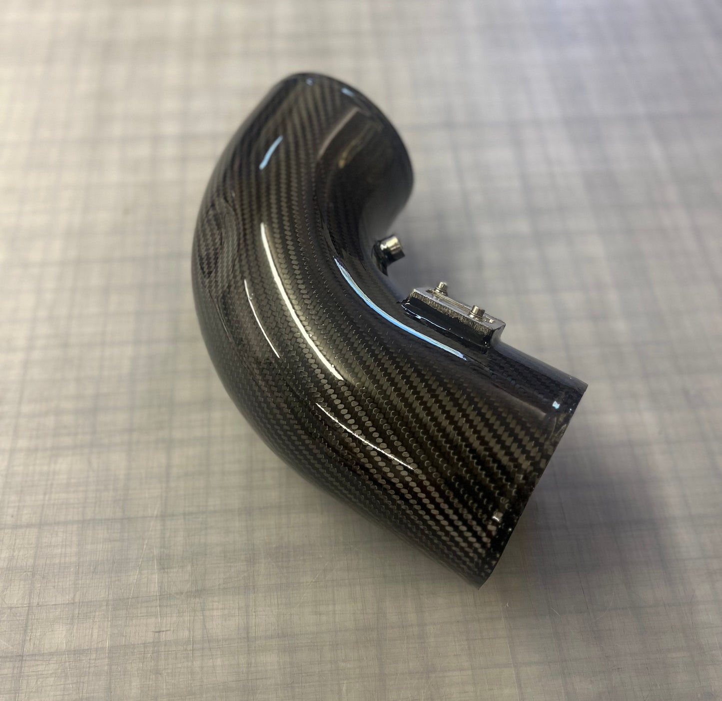 Carbon fiber exhaust tip on a checkered background