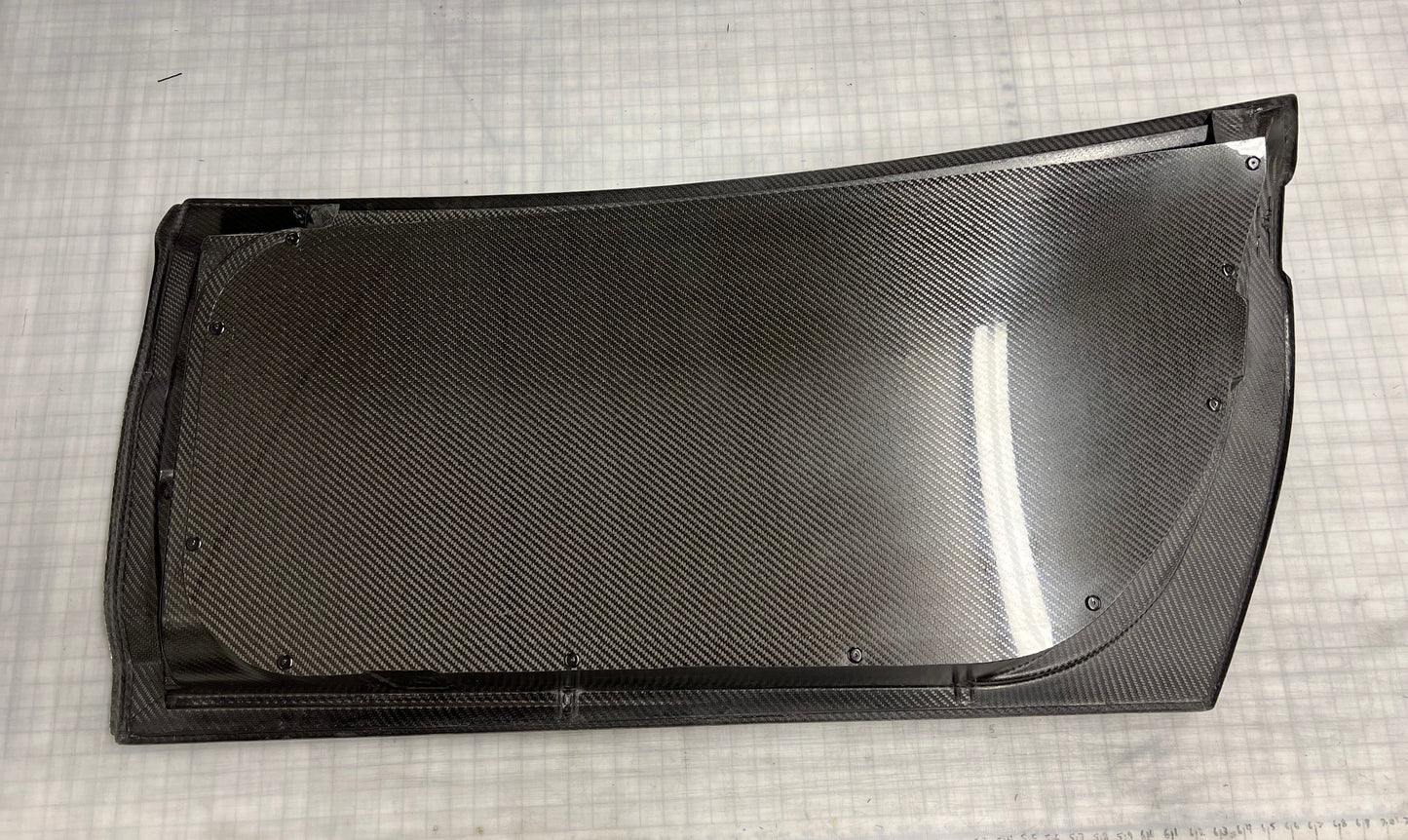 A C6 Corvette with carbon fiber doors installed, showing the doors in an open position with a focus on the door's texture and finish.