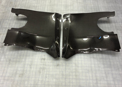 Carbon fiber car body panels on a textured gray surface