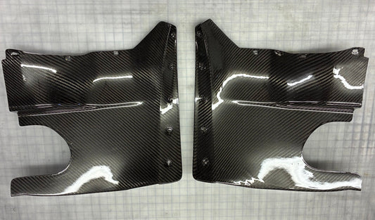 Two carbon fiber car parts on a checkered background