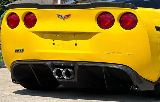 Yellow Corvette car with visible branding on a road