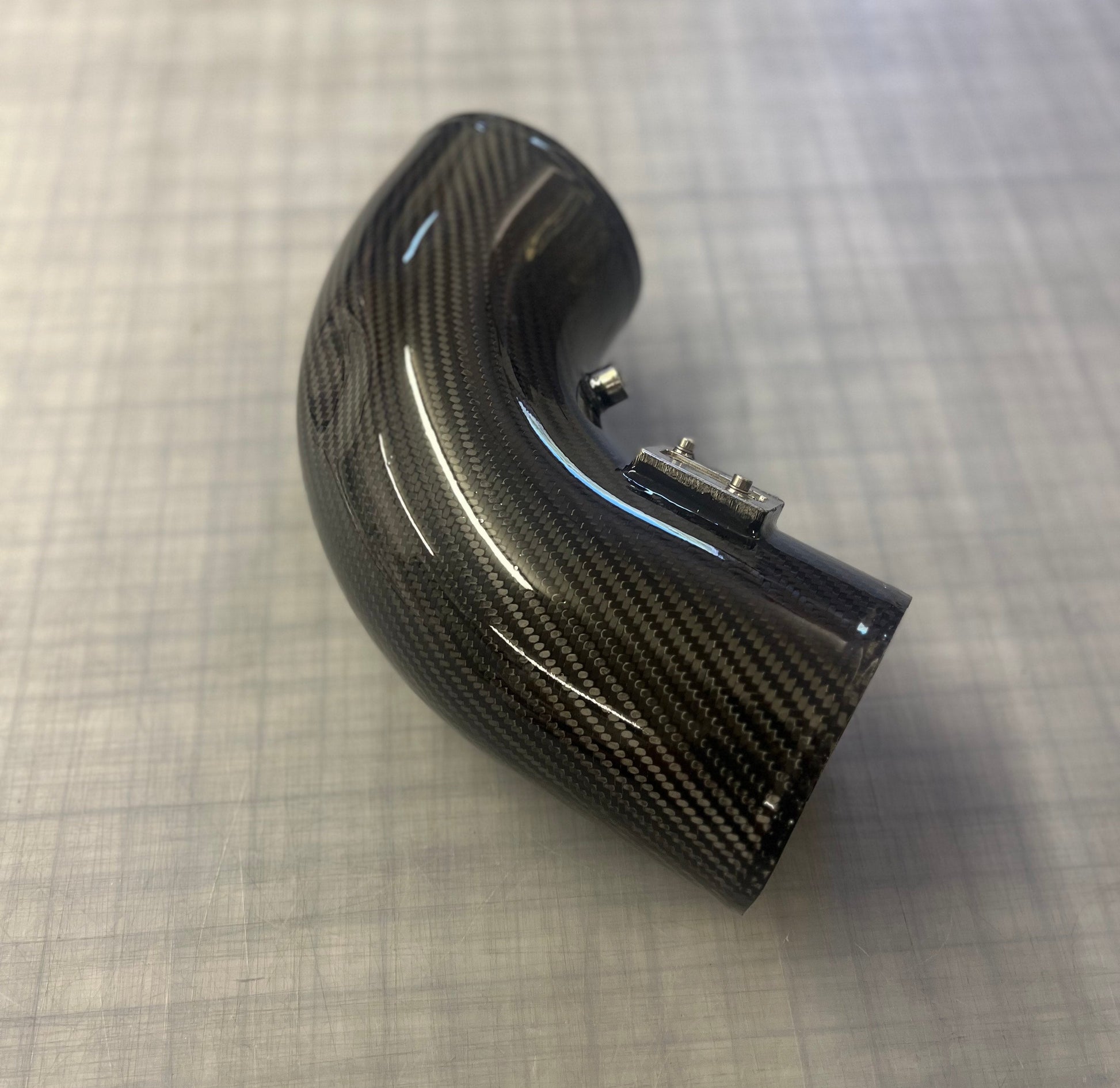Carbon fiber exhaust tip on a checkered background