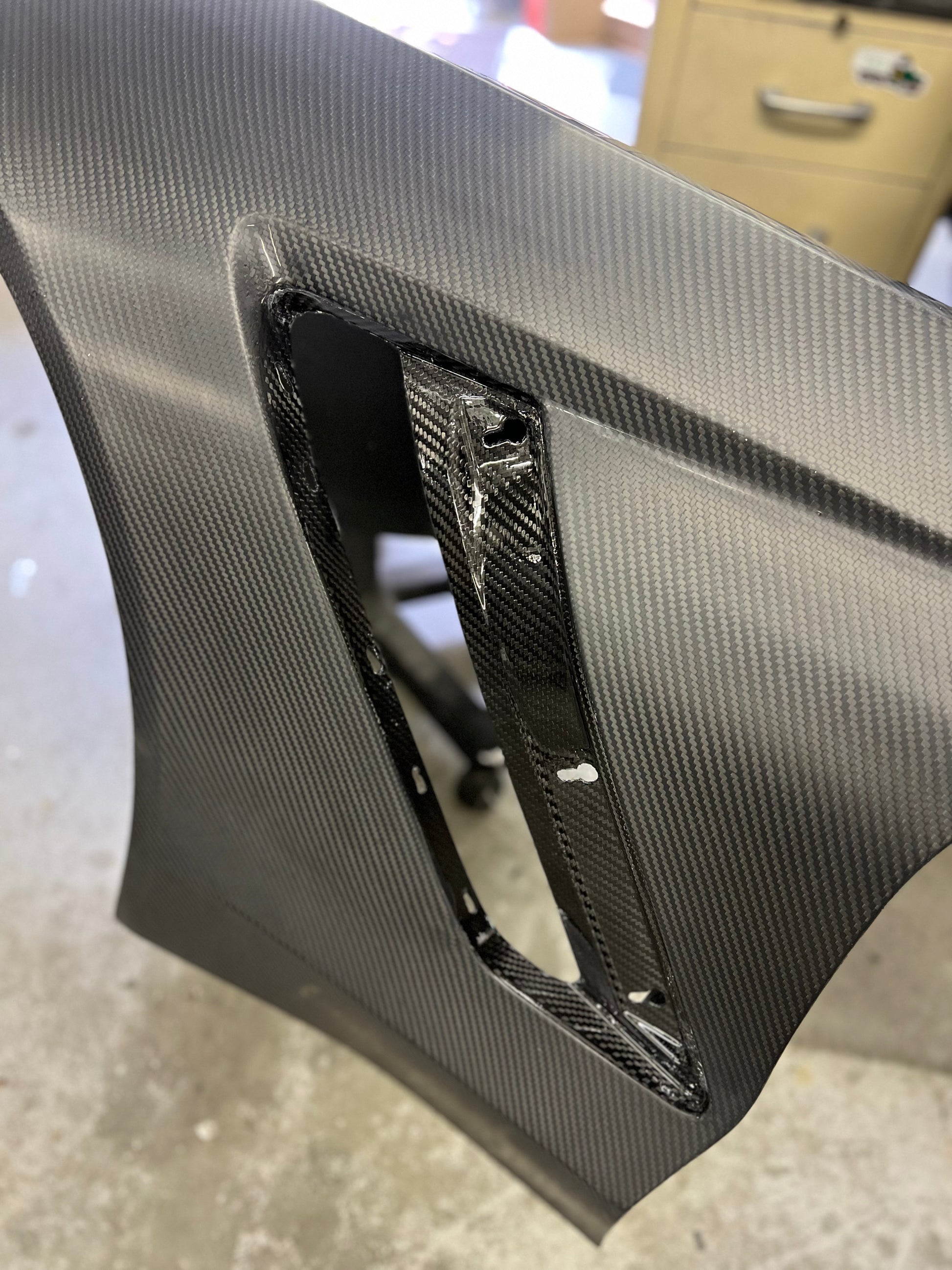 Carbon fiber panel with a cutout on a textured surface