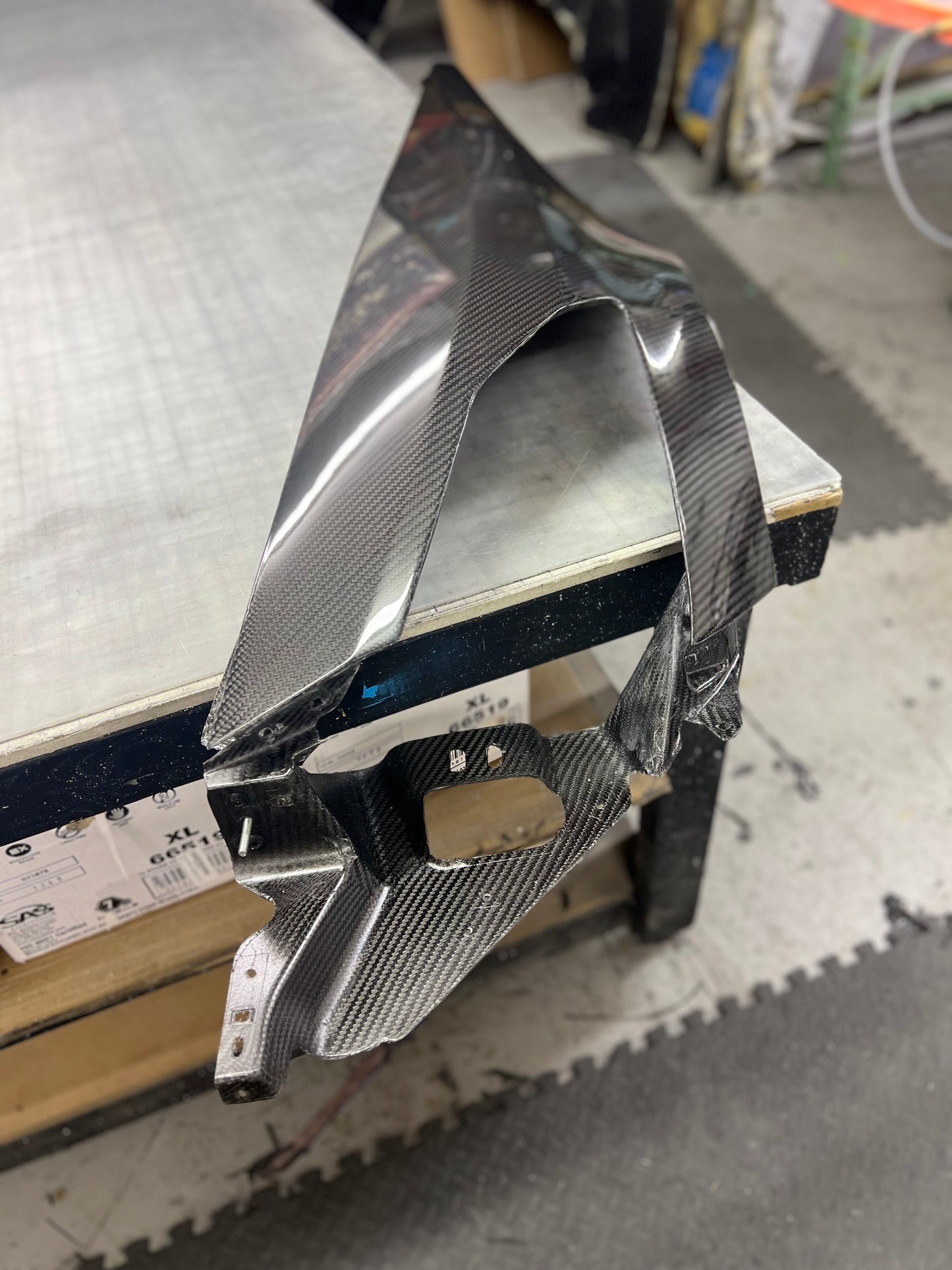 Carbon fiber winglet on a stand with a workshop background