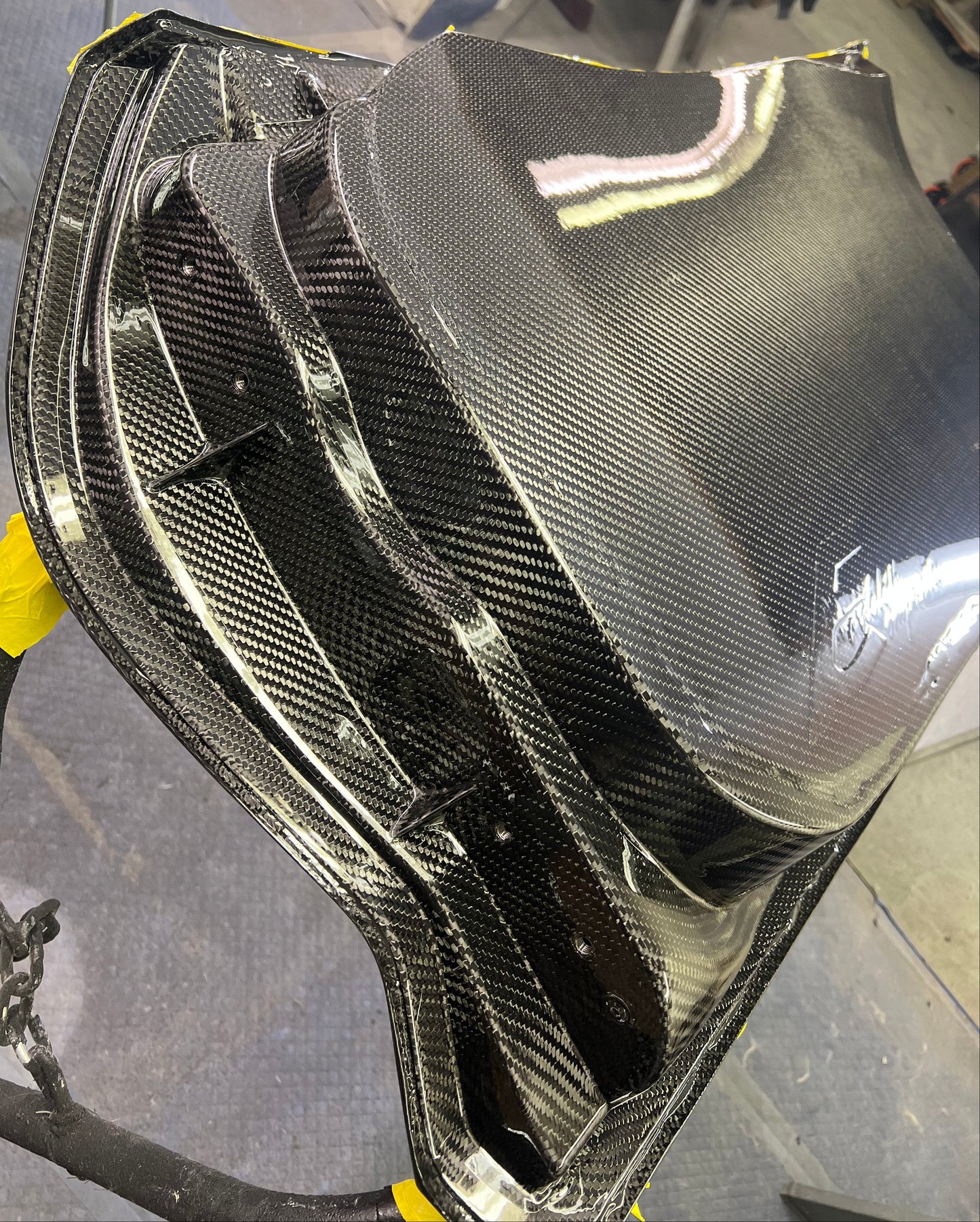 Carbon fiber car part on a gray surface