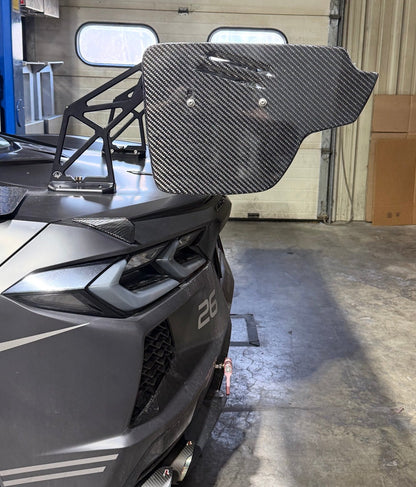 Gray vehicle with a large black rear window in a garage setting