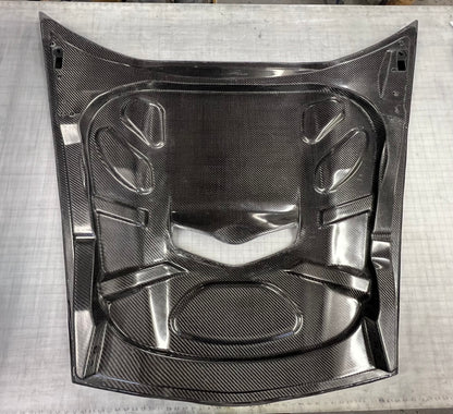 Carbon fiber car hood on a textured gray surface