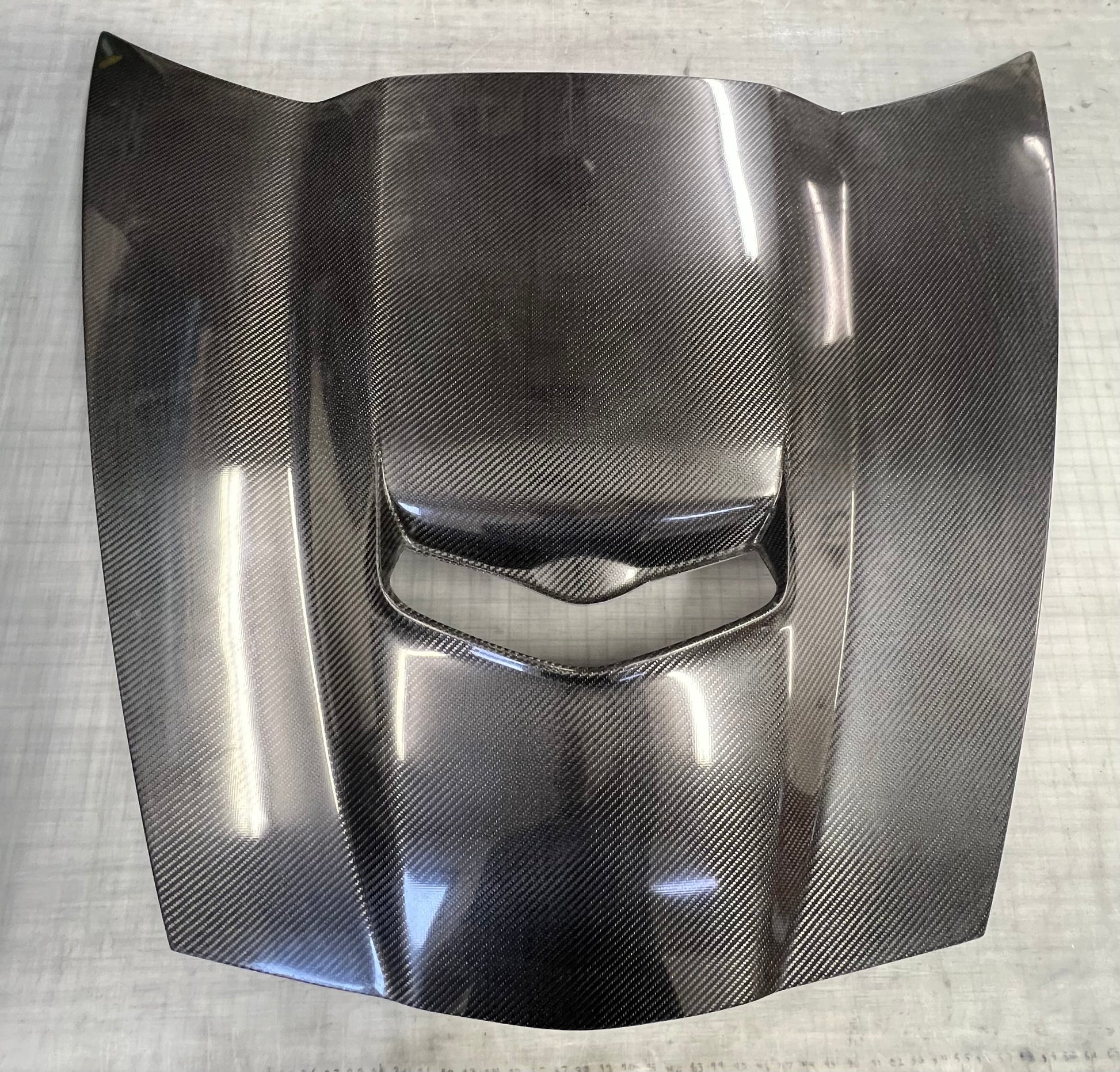 Carbon fiber car hood on a textured white background