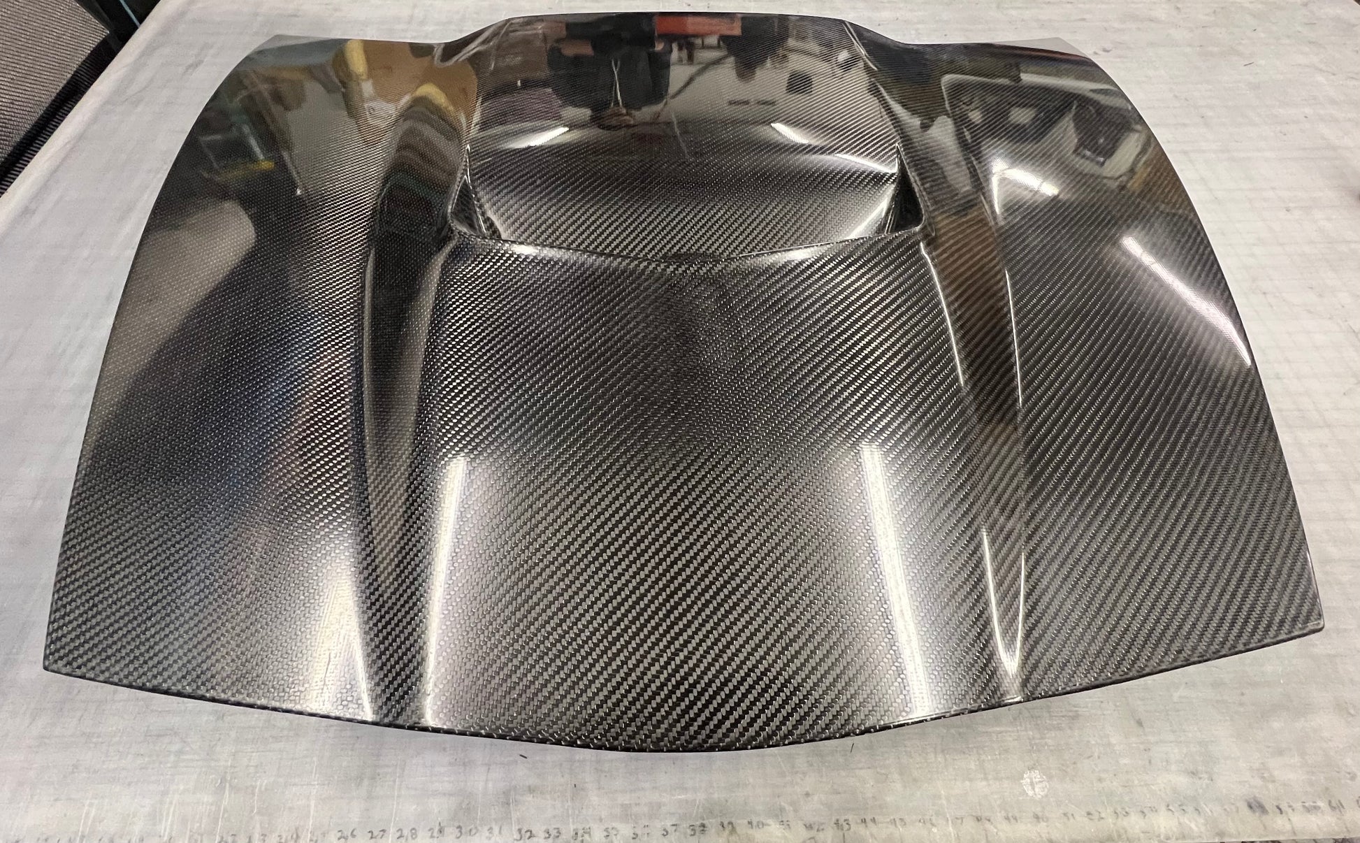 Carbon fiber hood with a smooth surface on a white background