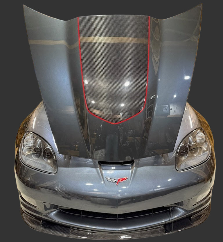 Car hood with carbon fiber finish in a workshop setting