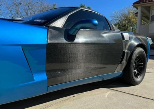A C6 Corvette with carbon fiber doors installed, showing the doors in a closed position with a focus on the door's texture and finish.
